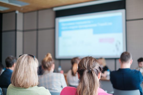 Businesswomen looking at diagram on projection screen